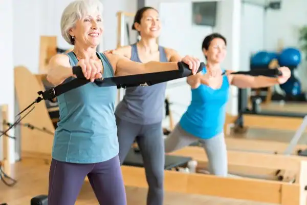 Toning Arms After 60: Empowering Womens Fitness Through Effective Weight Training 2 older woman doing weight training Hastings and resistance in the gym to tone upper arms