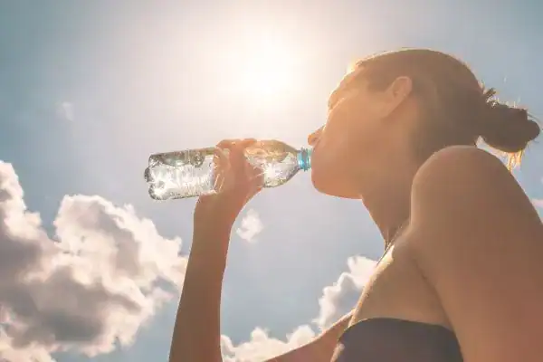 Hydration: The Secret Ingredient for a Toned Stomach and Enhanced Fitness 3 Image of woman drinking water to hydrate Hastings after run.